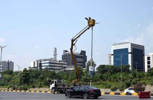 An IESCO worker restores a street light along Srinagar Highway, ensuring brighter nights for commuters in the Federal Capital