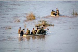 Army personnel evacuate stranded flood victims by boats near Bhuwana on Lalian Road after the Chenab River overflowed its banks.