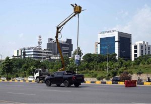 An IESCO worker restores a street light along Srinagar Highway, ensuring brighter nights for commuters in the Federal Capital