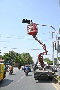A cantonment worker is busy installing new traffic signals at College Road.