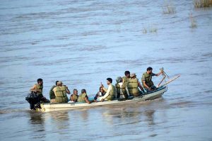 Army personnel evacuate stranded flood victims by boats near Bhuwana on Lalian Road after the Chenab River overflowed its banks.