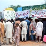 Flood affected people waiting for their turn outside a relief camp to get food and medicine in Mouza Kalri, Lalian Road, Tehsil Bhuwana, near the Chenab River 