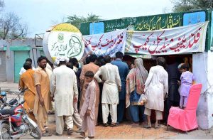 Flood affected people waiting for their turn outside a relief camp to get food and medicine in Mouza Kalri, Lalian Road, Tehsil Bhuwana, near the Chenab River 