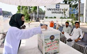 A student donates funds for flood victims at a relief camp set up by the University of Sargodha at Gate No. 3.
