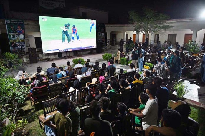 People are watching the live Asia Cup final match between Pakistan and India on big screen outside Niaz Cricket Stadium