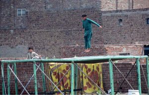 Children enjoy jumping on a roadside jumping jack set up on the outskirts of the city.