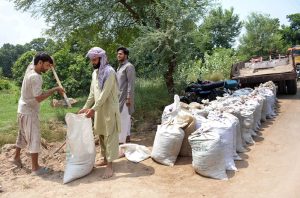 Workers fill sandbags to strengthen embankments as a precautionary measure to prevent possible flooding.