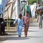 People move to higher ground after rising water levels in the Chenab River inundated low-lying areas