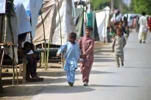 People move to higher ground after rising water levels in the Chenab River inundated low-lying areas