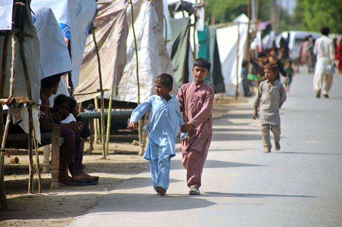 People move to higher ground after rising water levels in the Chenab River inundated low-lying areas
