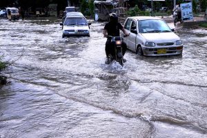 Kids cycle through accumulated rainwater on a street in Gulshan-e-Kaneez Fatima Society, where flooded roads continue to cause severe problems for residents despite the rain having stopped for two days