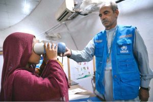 An Afghan refugee girl being de-registered by UNHCR staff at the Voluntary Repatriation Center before returning to Afghanistan