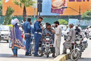 Traffic wardens giving Challan to the motorists on violating traffic rules at Kachehri Chowk.