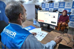 An Afghan refugee girl being de-registered by UNHCR staff at the Voluntary Repatriation Center before returning to Afghanistan