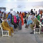 Afghan refugee families wait for their turn to be de-registered at the UNHCR repatriation center before departing for Afghanistan