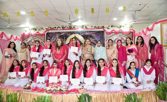 Students pose for a group photo with Professor Dr. Fareeha Hikmat during the Milad ceremony at Associate College for Women, Dhoke Elahi Bakhsh