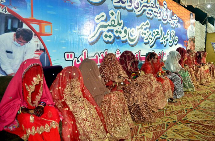 Brides sitting on stage during a mass wedding ceremony organized by Jillani Welfare Foundation at Bagh-e-Mustafa Ground