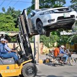 City Traffic Police personnel are using lifters to remove illegally parked vehicles from the road