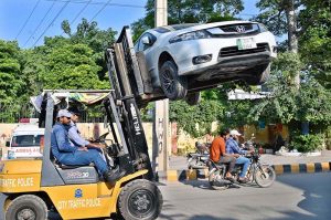 City Traffic Police personnel are using lifters to remove illegally parked vehicles from the road