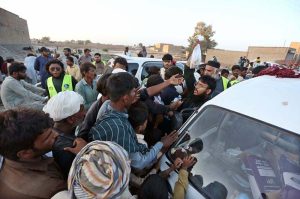 Residents help move a boat to rescue stranded families in flood-hit areas