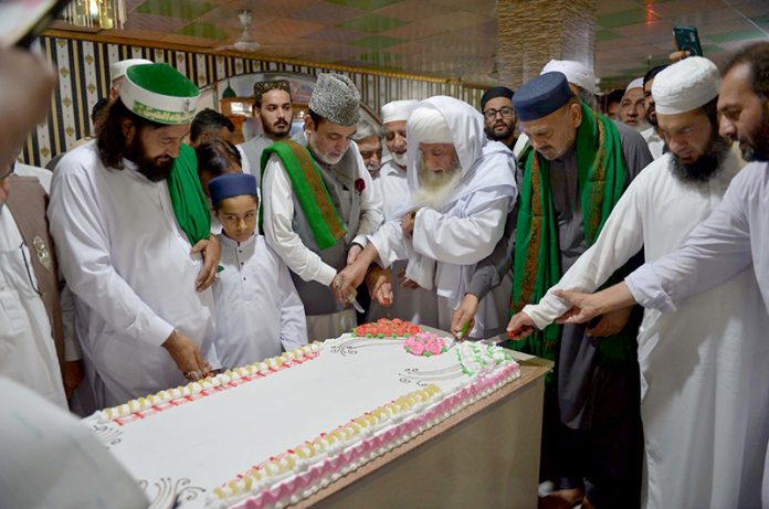 People cutting cake on the eve of Eid Milad-un-Nabi (SAWW) commemoration of the birth anniversary of Prophet Mohammed (SAAW)