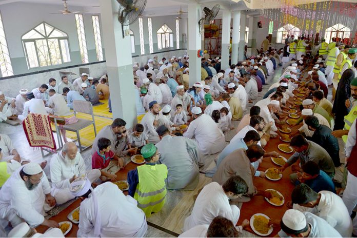 Volunteers serving langar to participants of Eid Milad-un-Nabi (SAWW) rally at the shrine of Hazrat Sheikh Junaid Baba Ji
