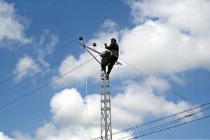A WAPDA staffer is busy installing new electricity lines in Sachal Colony