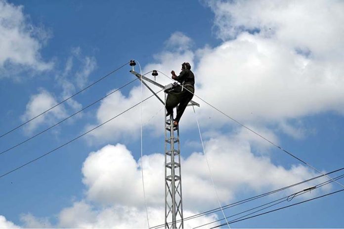 A WAPDA staffer is busy installing new electricity lines in Sachal Colony