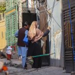 A polio worker marks the house of a child after administering polio drops during the anti-polio vaccination campaign at Tarlai area in the Federal Capital
