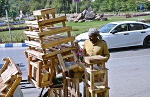 A street vendor displaying wooden bases of refrigerators and stools on his bicycle at G-8 in Federal Capital.