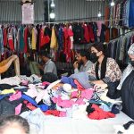 Women busy in selecting and purchasing old warm clothes at weekly bazaar in the Federal Capital