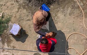 A polio worker marks the house of a child after administering polio drops during the anti-polio vaccination campaign at Tarlai area in the Federal Capital