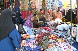 Women are busy selecting and purchasing old cloth pieces from stall at I-9/4 weekly bazaar in Federal Capital.