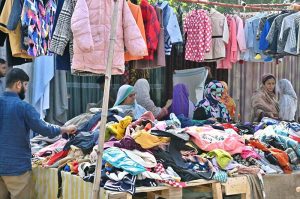 Women are busy selecting and purchasing second hand warm clothes from vendor at weekly bazaar, I-9/4 in the Federal Capital.