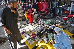 Women are busy selecting and purchasing old cloth pieces from stall at I-9/4 weekly bazaar in Federal Capital.