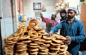 A bakeman prepares traditional crispy butter bread (Baqir Khani) in a tandoor at his workplace, people often enjoyed at breakfast.