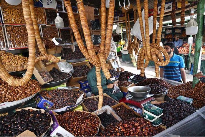 A vendor displaying different types of dates and dry fruit to attract the customers at weekly bazaar in the Federal Capital