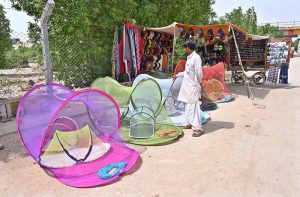 A vendor displaying mosquito nets to attract the customers at Jamshoro Road.