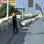 A worker placing plant pots on the Six Road Flyover as part of beautification efforts in the city