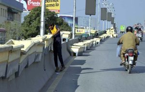 A worker placing plant pots on the Six Road Flyover as part of beautification efforts in the city