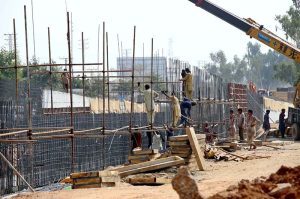 Labourers are busy construction work of T-Chowk Flyover during development work in Federal Capital.