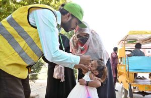 A polio health worker administers drops to a child during the anti-polio drive at Dr. Faisal Masood Teaching Hospital