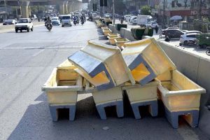 A worker placing plant pots on the Six Road Flyover as part of beautification efforts in the city