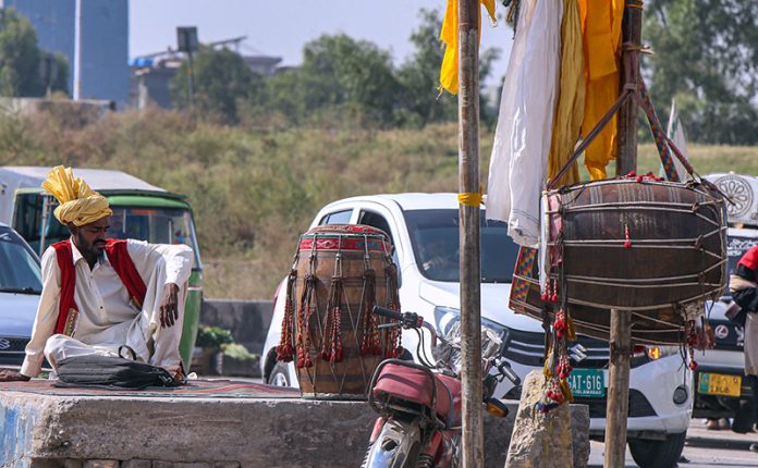 Dhol player waiting for customers at his roadside setup in the Federal Capital Dhol player waiting for customers at his roadside setup in the Federal Capital
