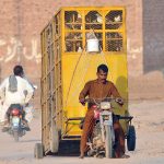 A motorcyclist on the way attached a huge bird cage with his motorcycle heading towards his destination