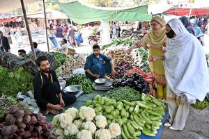 Woman purchasing vegetables from vendor at weekly bazaar, I-9/4 in the Federal Capital.