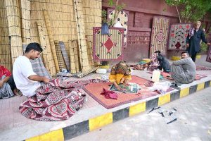 Workers busy in preparing the traditional curtains (chicks) on the footpath along Court Road.