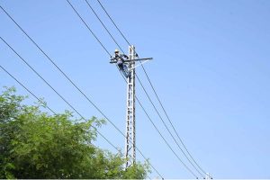 WAPDA workers busy in installing new electricity cables on electric pole at Tarlai.