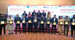 Federal Minister for Education and Professional Training Dr. Khalid Maqbool Siddiqui, Federal Minister for Overseas Pakistanis and Human Resource Development Chaudhry Salik Hussain, Chairperson NAVTTC Gulmina Bilal Ahmad, and Deputy Ambassador of the European Union to Pakistan Philipp Cliver Gross in a group photo with representatives of the best institute with the highest employment rate, holding shields during the Two-Day International Dialogue on “TVET in the Shifting Socio-Economic Paradigm” at a local hotel.