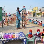 A vendor displaying dolls to attract customers at his roadside setup